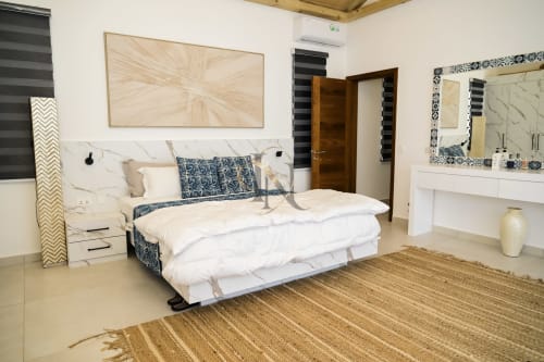 Chambre moderne de la Villa No. 5 Coin des Zils à Gerards & Angel, Petit Raffray, avec tête de lit en marbre et literie bleu motifs