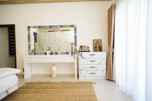 Chambre lumineuse avec coiffeuse en marbre et miroir à la Villa Coin des Zils, hôtel Petit Raffray