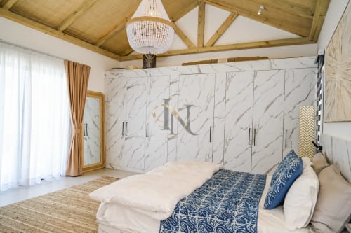 Chambre luxueuse de la villa Gerards & Angel avec mur en marbre, poutres plafond bois et vue piscine à Maurice