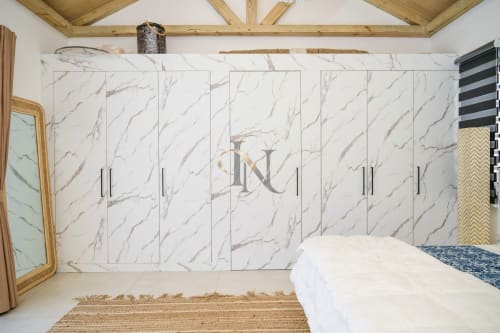 Chambre élégante avec dressing en marbre, literie blanche, poutres au plafond en bois et miroir doré à la villa Gerards & Angel