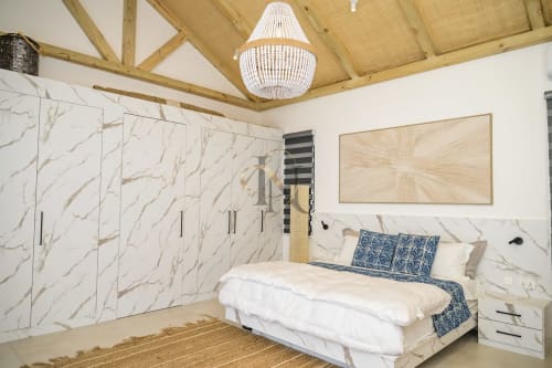 Chambre luxueuse à la villa Gerards & Angel à Maurice avec armoire en marbre, plafond à poutres et literie bleue à motifs