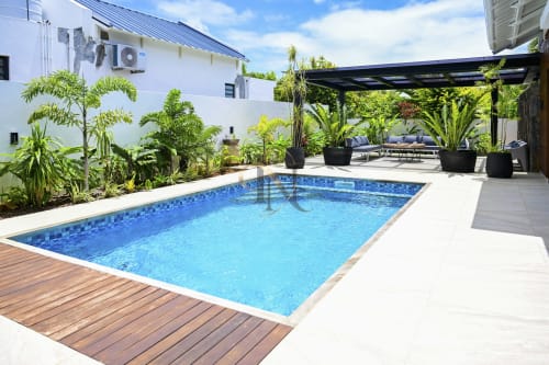 Piscine de la villa Gerards & Angel avec aménagement tropical, espace détente et bâtiment blanc à Petit Raffray