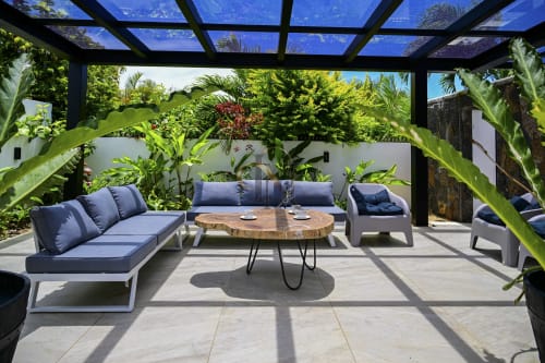 Zone de détente luxueuse de la villa Gerards & Angel à Maurice avec mobilier lounge, table en bois et plantes tropicales