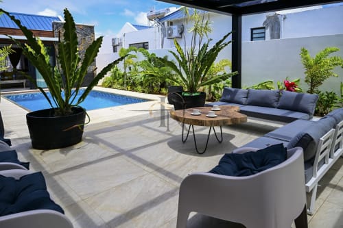 Terrasse piscine luxueuse à la villa Gerards & Angel avec coin détente, plantes tropicales et piscine bleue à l'Île Maurice