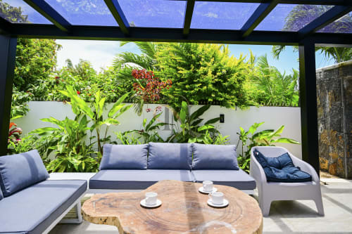 Espace détente extérieur de la villa Gerards & Angel à Maurice avec mobilier bleu, table en bois et jardin tropical