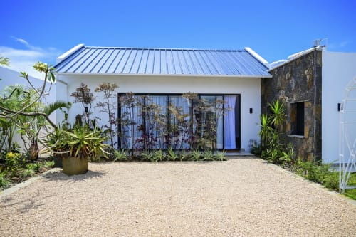 Villa moderne blanche avec toiture métallique bleue à Gerards & Angel, Petit Raffray, aménagement tropical et graviers