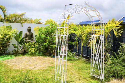 Pergola blanche avec plantes tropicales à la villa Gerards & Angel à Maurice, palmiers et statue de Bouddha