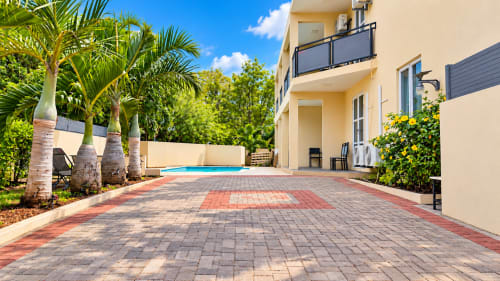 Martello Residence Apt 1 patio at Gerards & Angel, La Preneuse - poolside terrace with brick pavers, palm trees, and cream
