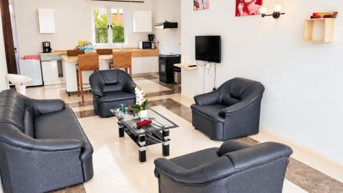 Modern living room at Martello Residence Apt 1, Gerards & Angel, featuring black leather seating, glass coffee table, and