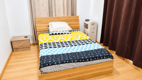 Bedroom at Gerards & Angel Martello Residence Apt 1 in La Preneuse with colorful patterned bedding, wooden furniture, and air