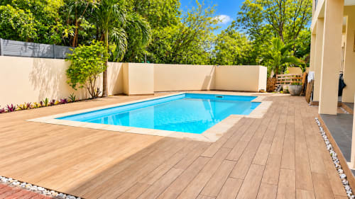 Gerards & Angel Martello Residence pool with wooden deck, turquoise water, and tropical greenery in La Preneuse