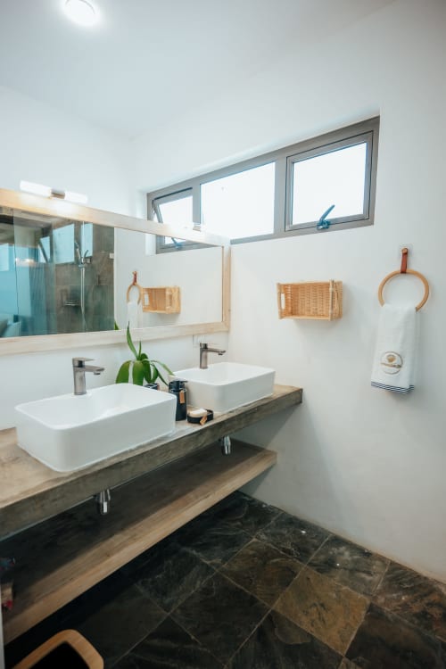 Modern bathroom at Gerards & Angel villa in Pereybere with dual sinks, wooden vanity, and natural light