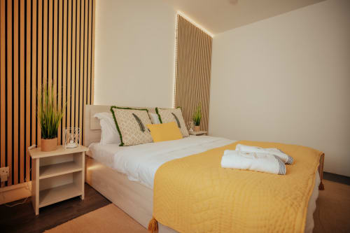 Summer of Hope villa bedroom at Gerards & Angel, Pereybere with yellow accents, wood paneling, and pool view