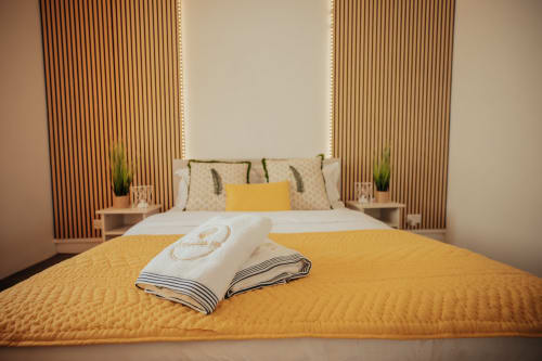Luxurious bedroom at Gerards & Angel villa in Pereybere with yellow bedding, decorative pillows, and modern furnishings.