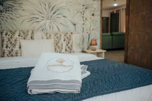Luxury villa bedroom at Gerards & Angel, Pereybere with decorative towel on teal bedding and tropical wallpaper