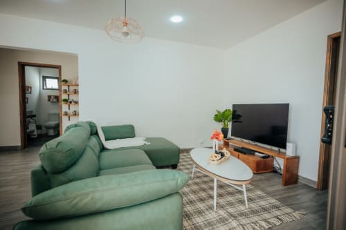 Modern living room at Summer of Hope villa in Pereybere with green sofa, flat screen TV, and white coffee table