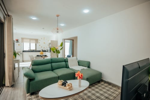 Modern villa living area with green sofa, white coffee table, and open kitchen at Gerards & Angel in Pereybere