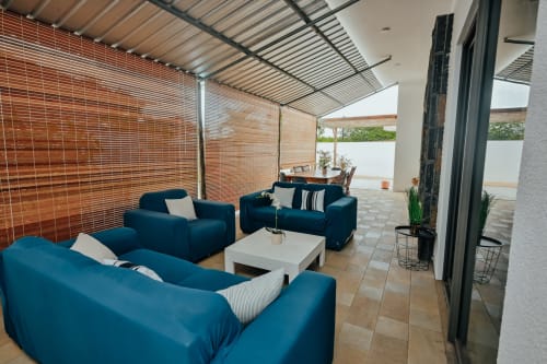 Modern villa sitting area at Gerards & Angel, Pereybere with blue sofas, white coffee table, and wooden privacy screens
