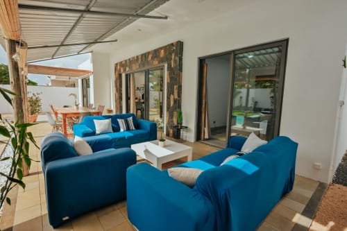 Blue sofas and white coffee table on terrace at Gerards & Angel villa in Pereybere with pool view