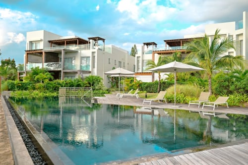 Appartement bord de mer Gerards & Angel à Pointe aux Piments avec piscine, terrasse, parasols, palmiers et architecture moderne