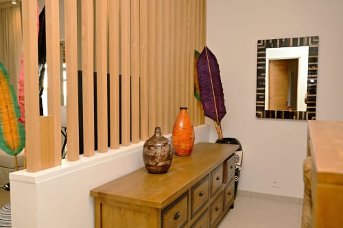 Chambre d'appartement face à la plage chez Gerards & Angel avec commode en bois, vases décoratifs et œuvres d'art d'inspiration africaine