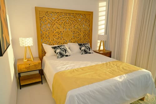 Chambre en bord de mer à Gerards & Angel, Pointe aux Piments avec tête de lit dorée ornementale, literie blanche et rideaux vue mer