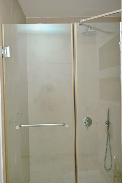 Salle de bain moderne avec douche vitrée, pomme de douche pluie et mitigeur manuel à l'appartement balnéaire Gerards & Angel, Pointe aux