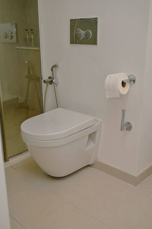 Salle de bain moderne de l'appartement Gerards & Angel avec toilettes murales, douchette bidet et vue sur l'océan face à la plage à Pointe aux
