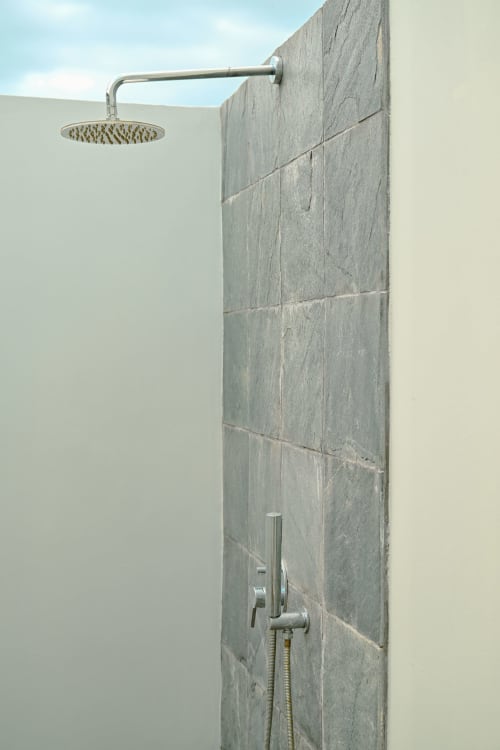 Douche extérieure moderne chez Gerards & Angel avec pomme de pluie, carrelage gris et vue sur l'océan à Pointe aux Piments