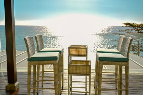 Places assises en bord de mer chez Gerards & Angel, Pointe aux Piments. Tabourets tressés aux coussins verts surplombent l'océan scintillant