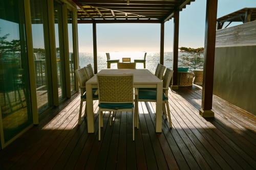 Terrasse face mer chez Gerards & Angel avec table à manger, chaises tressées et vue sur l'océan à Pointe aux Piments