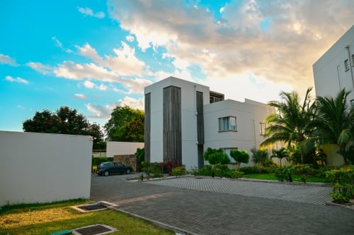 Immeuble blanc contemporain à Gerards & Angel à Pointe aux Piments avec palmiers et allée pavée