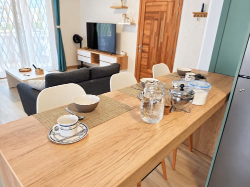 Modern dining table with place settings at Ti Palmier apartment in Flic-en-Flac, Mauritius with lounge and TV area