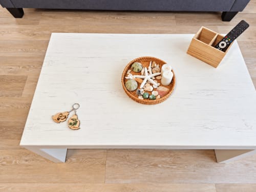 White dining table with woven basket of shells, remote control holder, and keychain at Ti Palmier apartment, Flic-en-Flac