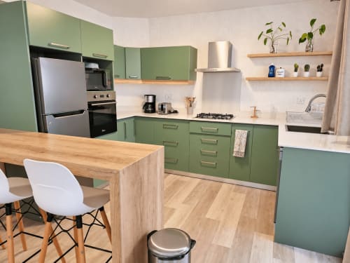 Modern green kitchen with wooden island and white chair in Ti Palmier apartment at Gerards & Angel, Flic-en-Flac