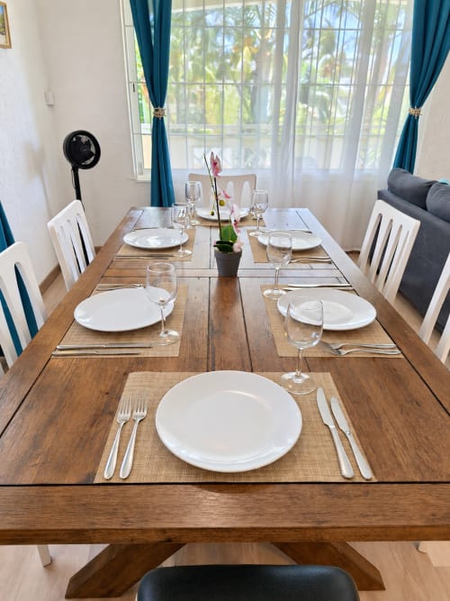Elegantly set dining table at Gerards & Angel, Flic-en-Flac, with place settings, glassware, and garden view through