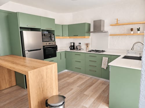 Modern green kitchen with wooden island, stainless steel appliances, and white countertops at Gerards & Angel, Flic-en-Flac