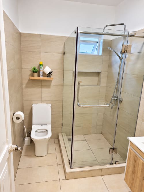 Modern bathroom in Ti Palmier apartment at Gerards & Angel, Flic-en-Flac with glass shower enclosure and toilet