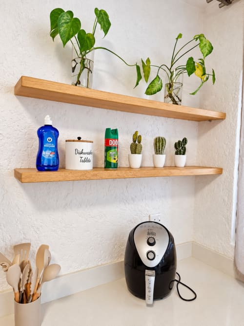 Kitchen shelf with potted plants, dishwasher tablets, and utensils at Gerards & Angel apartment in Flic-en-Flac