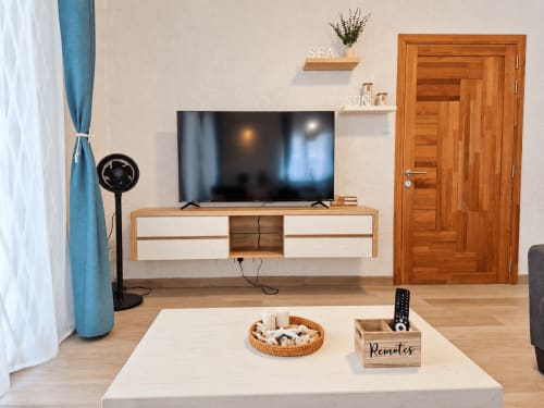 Modern living room in Ti Palmier apartment at Gerards & Angel, Flic-en-Flac with flat-screen TV, wooden entertainment unit,