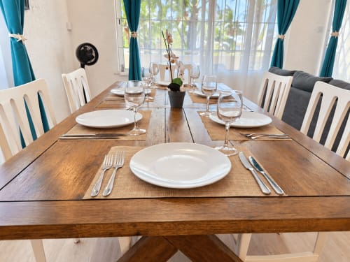 Elegantly set dining table at Gerards & Angel, Flic-en-Flac, with white plates, glasses, and orchid centerpiece