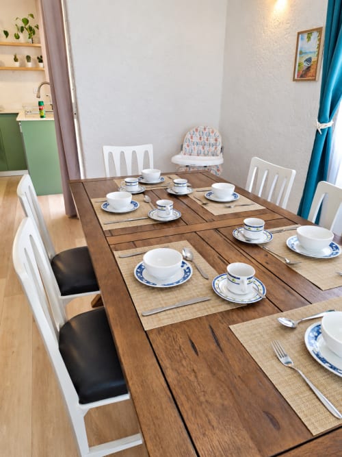 Dining table set for meal at Gerards & Angel Ti Palmier apartment in Flic-en-Flac with white chairs and blue-trimmed