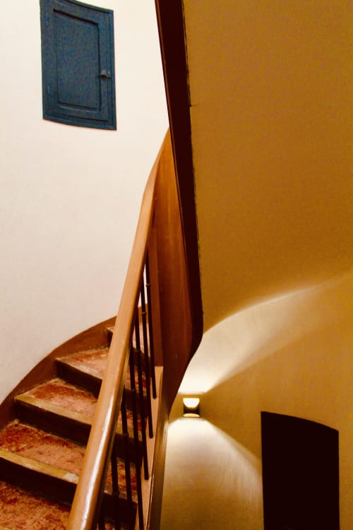 Escalier en bois avec rampe en fer dans le couloir d'une villa ocre-jaune, propriété d'hospitalité à Carcassonne
