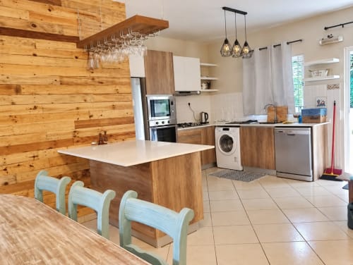 Modern kitchen with wooden accents, island seating, stainless steel appliances, and white countertops at Gerards & Angel