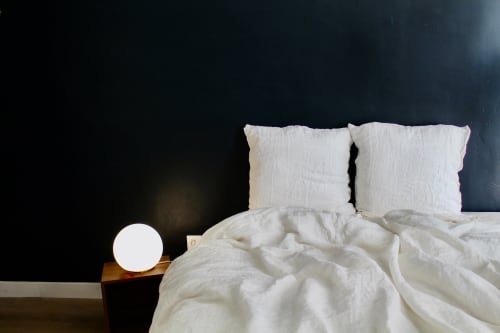 Chambre cosy de villa à Carcassonne avec oreillers blancs, draps frais et éclairage doux de chevet