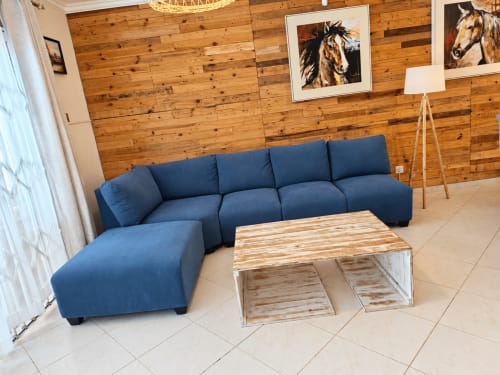 Modern living room at Gerards & Angel, Sirokann apartment in Flic en Flac with blue sectional sofa, wooden wall, and rustic