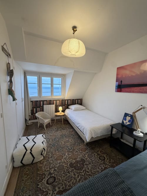 Chambre côtière au Mon Week End A La Mer avec vue mer, lit simple, fauteuil en rotin et fenêtres sur l'océan à Hautot-sur-Mer