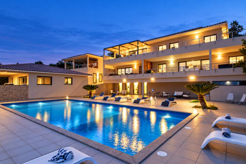 Villa de luxe à Zonza avec piscine illuminée, transats et architecture moderne au crépuscule