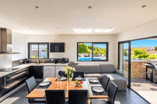 Cuisine ouverte et salle à manger moderne avec vue sur la mer aux Villas d'A Storia, Zonza