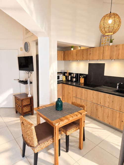 Modern kitchen and dining area in Bungalow 2 at Les Balcons D'oyster Pond, Saint-Martin, with wooden furnishings and equipped